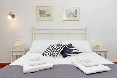 a white bed with two towels on top of it at 4BNB - Queen Mary Vatican Home in Rome