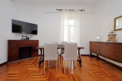 a dining room with a table and white chairs at 4BNB - Queen Mary Vatican Home in Rome