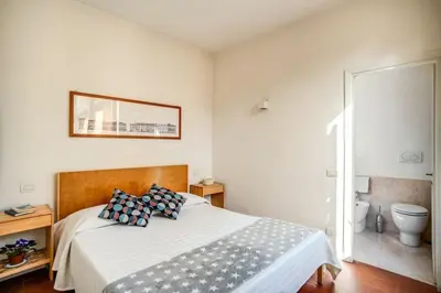 a bedroom with a bed and a toilet and a mirror at Coliseum charming house in Rome
