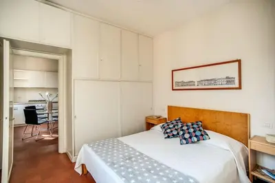 a bedroom with a large bed and a kitchen at Coliseum charming house in Rome