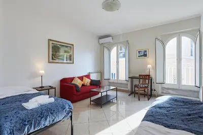 a bedroom with a bed and a red couch at Close to the Spanish Steps, WIFI, Air Cond, 2 bedrooms in Rome