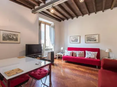 a living room with a red couch and a table at Piazza Navona Charming Apartment in Rome