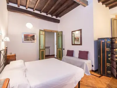 two beds in a room with white walls and wooden floors at Piazza Navona Charming Apartment in Rome