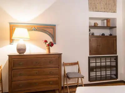 a bedroom with a dresser with a lamp and a chair at Piazza Navona Charming Apartment in Rome