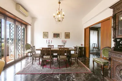 a dining room with a table and chairs and a chandelier at Rosso Levanto House in Rome
