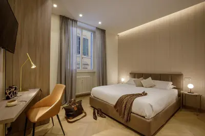 a bedroom with a bed and a desk and a window at Daplace - Felicia Apartment in Rome