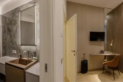 a bathroom with a sink and a table with a chair at Daplace - Felicia Apartment in Rome