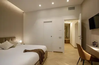 a bedroom with a bed and a desk and a television at Daplace - Felicia Apartment in Rome
