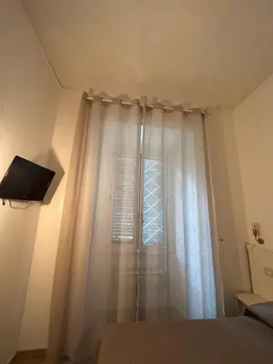 a bedroom with a white curtain and a window at Hedi-Don sweet home-103 in Rome