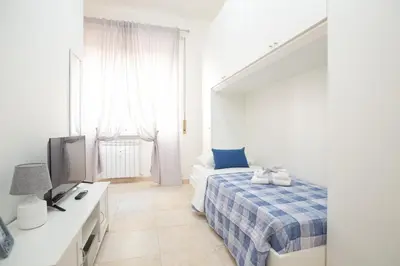 a white bedroom with a bed and a television at Casa Luna in Rome