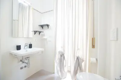 a white bathroom with a sink and a toilet at Casa Luna in Rome