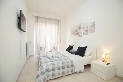 a white bedroom with a bed and a window at Casa Luna in Rome
