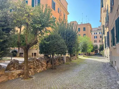 a cobblestone street with trees in front of a building at Vaticano Apartment in Rome