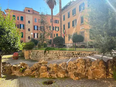 a stone retaining wall in front of some buildings at Vaticano Apartment in Rome