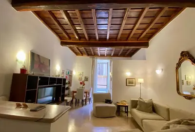 a living room with a wooden ceiling and a couch at Idi's House in Rome