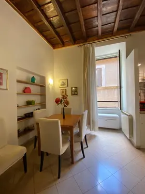 a dining room with a table and chairs and a window at Idi's House in Rome