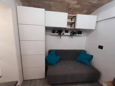 a living room with a couch and white cabinets at RomAmoR Spagna in Rome