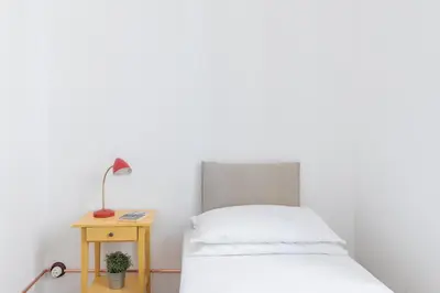a bedroom with a bed and a table with a lamp at iFlat Bright Brand New 3-Bedroom Apt in Monti in Rome