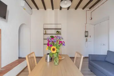 a vase of flowers on a wooden table in a living room at iFlat Bright Brand New 3-Bedroom Apt in Monti in Rome