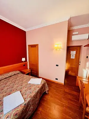 a bedroom with a bed and a red wall at Beauty Rooms in Rome
