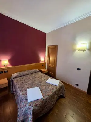 a hotel room with a bed and a desk and a bed sidx sidx sidx at Beauty Rooms in Rome