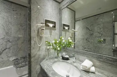 a bathroom with a sink and a mirror and a tub at Vibe Nazionale in Rome