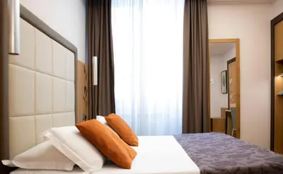 a bedroom with a bed with brown and white pillows at Vibe Nazionale in Rome