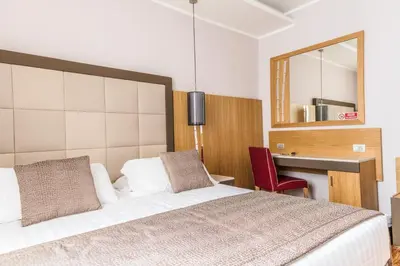 a bedroom with a bed and a desk and a mirror at Vibe Nazionale in Rome
