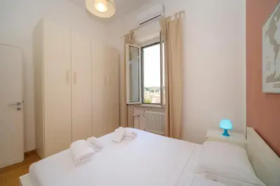 a bedroom with a white bed and a window at Clivo 2 St Peter BuddyRent in Rome