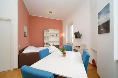 a room with a table and blue chairs and a bed at Clivo 2 St Peter BuddyRent in Rome