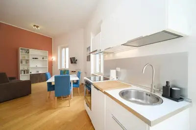 a kitchen with a sink and a living room at Clivo 2 St Peter BuddyRent in Rome