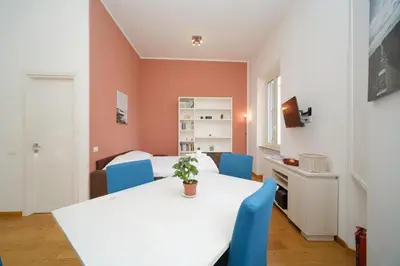 a dining room with a white table and blue chairs at Clivo 2 St Peter BuddyRent in Rome