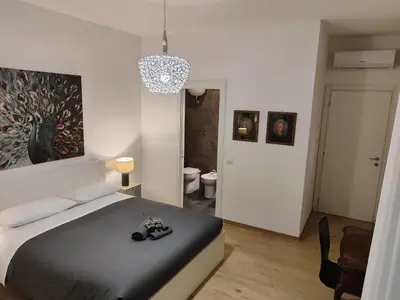 a bedroom with a bed and a chandelier at A&B Vatican Domus in Rome