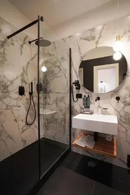 a bathroom with a sink and a shower with a mirror at No Man's Land Guesthouse in Rome