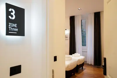 a room with two beds and a sign on the wall at No Man's Land Guesthouse in Rome