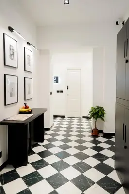 a hallway with a black and white checkered floor at No Man's Land Guesthouse in Rome
