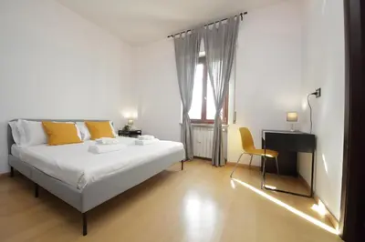 a bedroom with a white bed and a yellow chair at Cozy and comfy apartment in Piramide metro stop in Rome