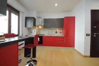 a kitchen with red cabinets and a black counter top at Cozy and comfy apartment in Piramide metro stop in Rome
