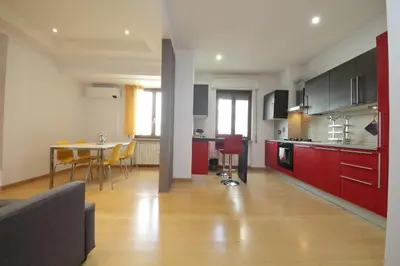 a kitchen with red cabinets and a table with chairs at Cozy and comfy apartment in Piramide metro stop in Rome