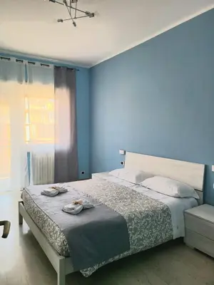 a blue bedroom with a bed and a chair at VIVA Rome Apartment 