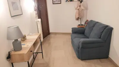 a living room with a blue chair and a table at VIVA Rome Apartment 