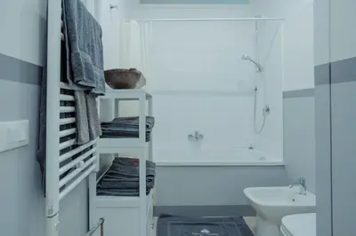 a white bathroom with a sink and a toilet at Domus Superior Domizio - Pantheon in Rome