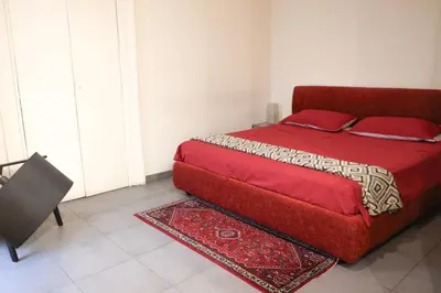 a bedroom with a red bed with a rug on it at Domus Superior Domizio - Pantheon in Rome