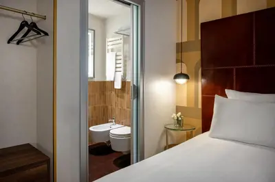 a bedroom with a bed and a bathroom with a toilet at Maison Roma Piazza di Spagna UNA Esperienze in Rome