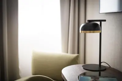 a lamp sitting on a table next to a chair at Maison Roma Piazza di Spagna UNA Esperienze in Rome