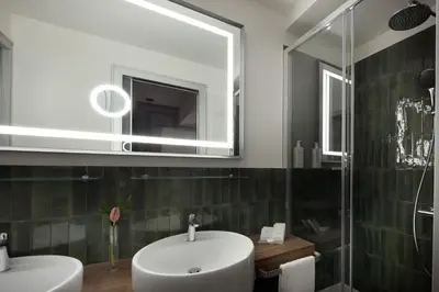 a bathroom with a sink and a mirror and a shower at Maison Roma Piazza di Spagna UNA Esperienze in Rome