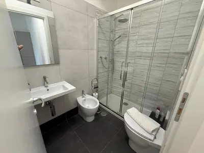 a bathroom with a shower and a toilet and a sink at Voluptas House Termini San Lorenzo in Rome