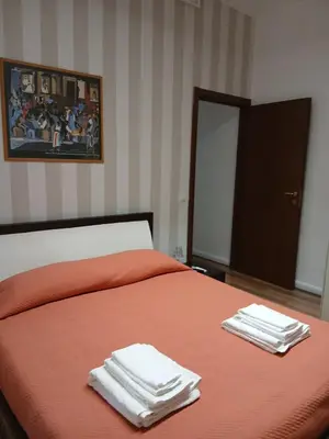 a bedroom with a orange bed with towels on it at Gianicolo House in Rome