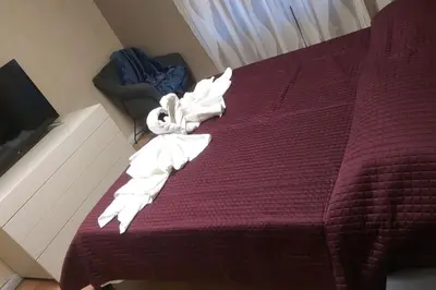 a red bed with a pile of white towels on it at Gianicolo House in Rome