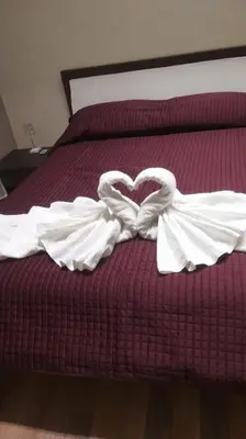 a bed with two white towels forming a heart at Gianicolo House in Rome